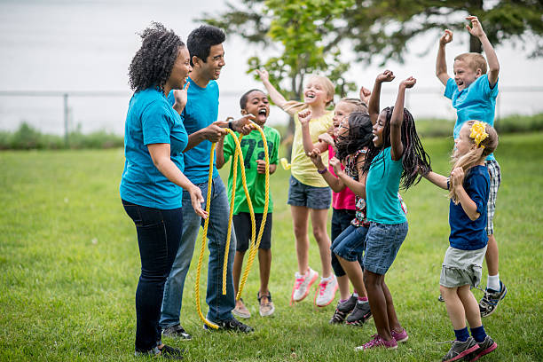 Our program diverse kids day camp playing tug of war.