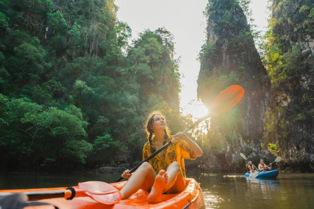 Our program young caucasian woman sea kayaking among karst formations krabi